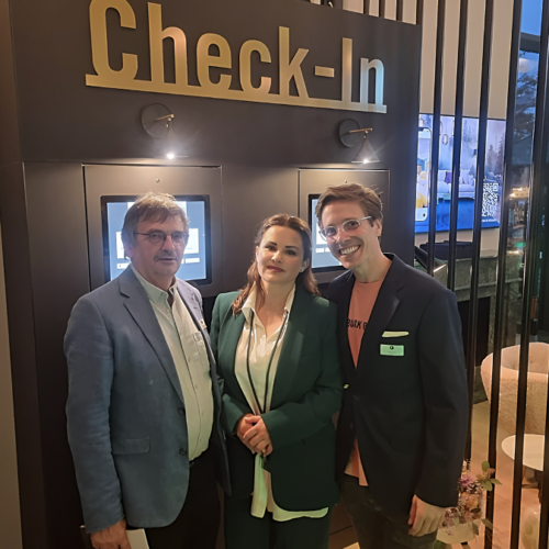 Check-in Design Terminal BLACKF Empfang Drei Personen stehen vor dem digitalen Check-in Design Terminal bei BLACKF Stuttgart. Im Hintergrund ist das elegante Empfangsdesign mit dem Schriftzug „Check-In“ zu sehen.